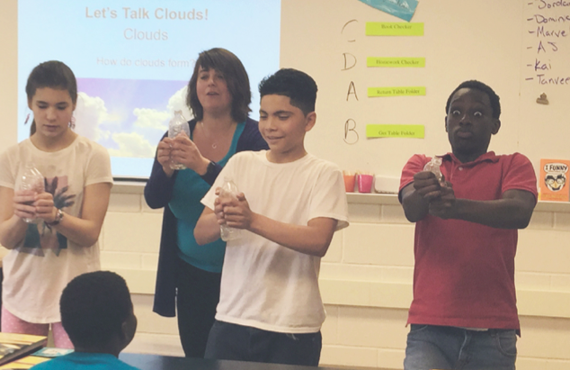 Students squeezing bottles to make clouds